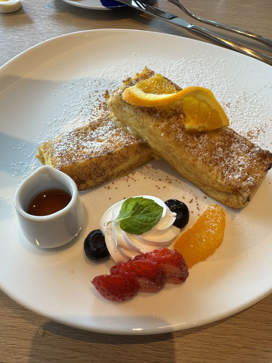 French toast with orange slices, berries, cream and syrup