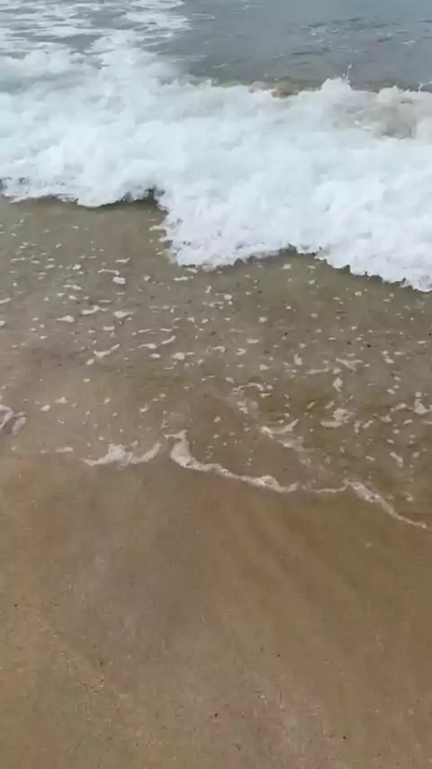 Waves washing over the sand at the beach in Itoshima