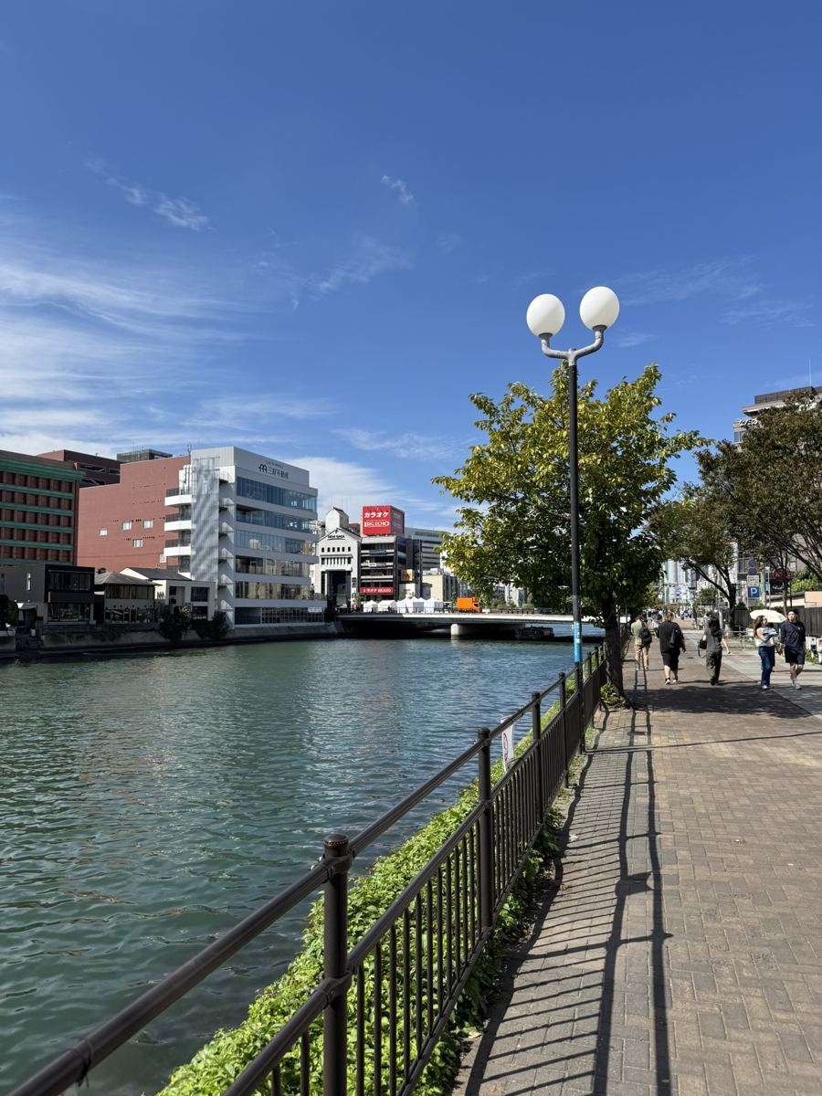 The Naka River on a sunny day with a riverside promenade and city buildings